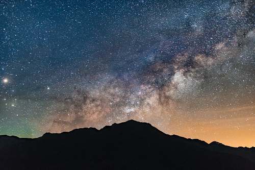 milky way silhouette photo of mountain during nighttime galaxy